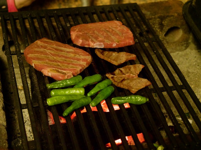 あみの上で焼いている肉とししとう